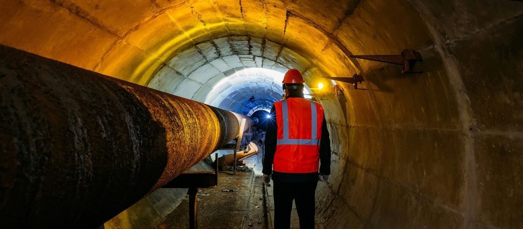 Man standing in underground water pipeline