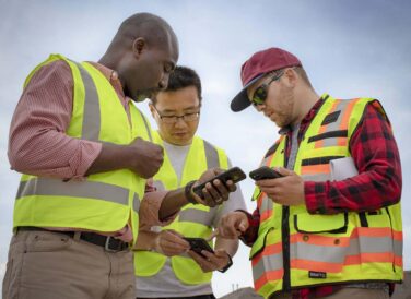 three men on mobile phones working on GIS project