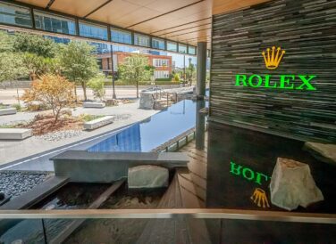 Rolex logo above building water feature front entrance