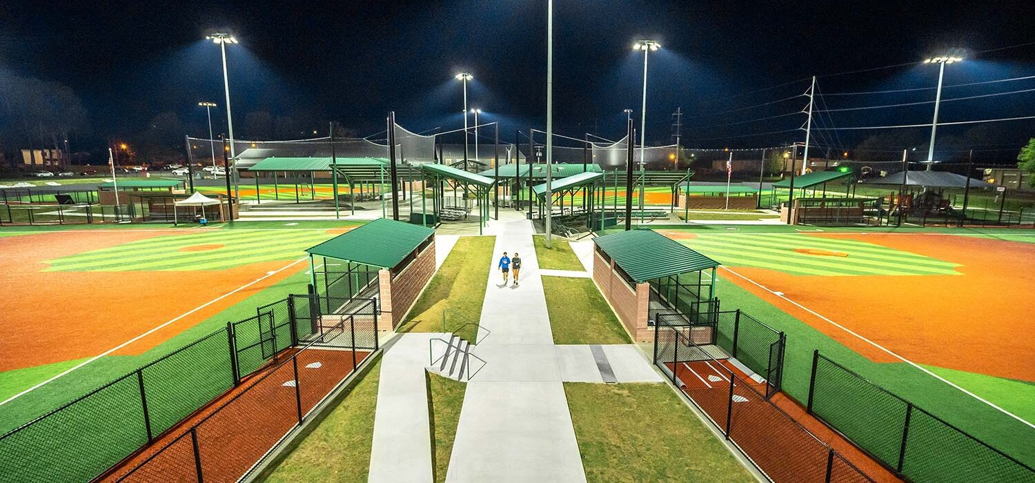 sidewalk between baseball fields at night at Majestic Park