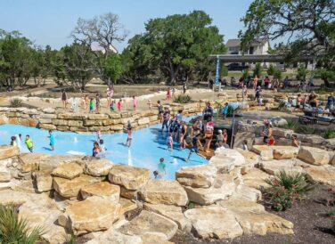 splash area with families and kids playing at Leander Lake Park