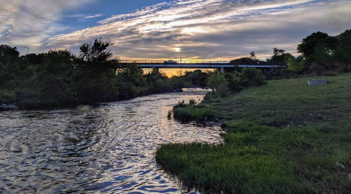 River by grass at sunset