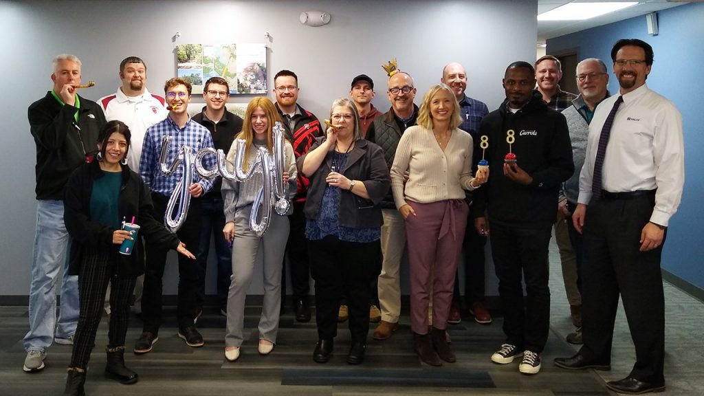 Halff's Oklahoma City office team posing with cupcakes and party blowers to celebrate 8th anniversary