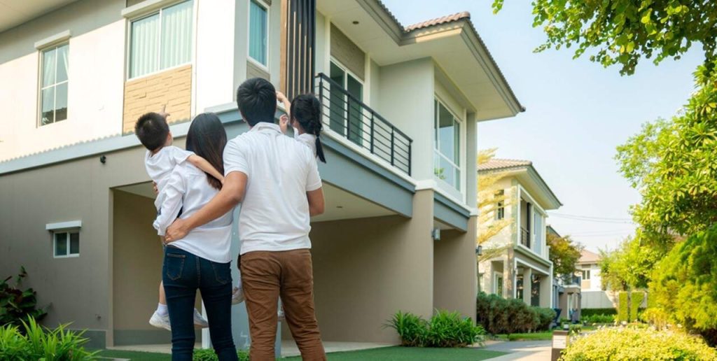 Young family standing outside in front of a row of nice homes in Florida