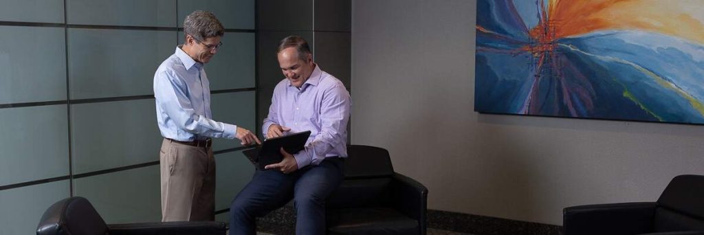 two male engineers collaborating together using a laptop utilizing artificial intelligence and machine learning for AEC