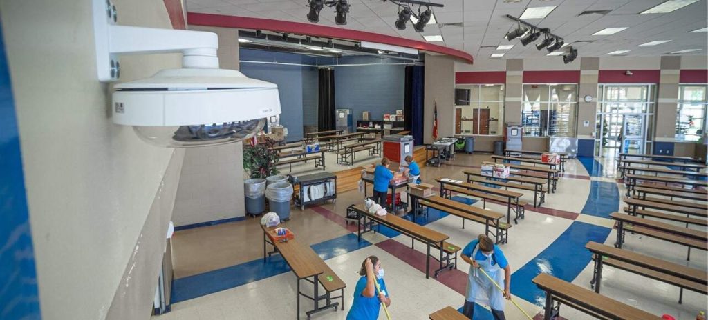 closeup of an indoor video surveillance camera on ceiling in a school cafeteria using ICT