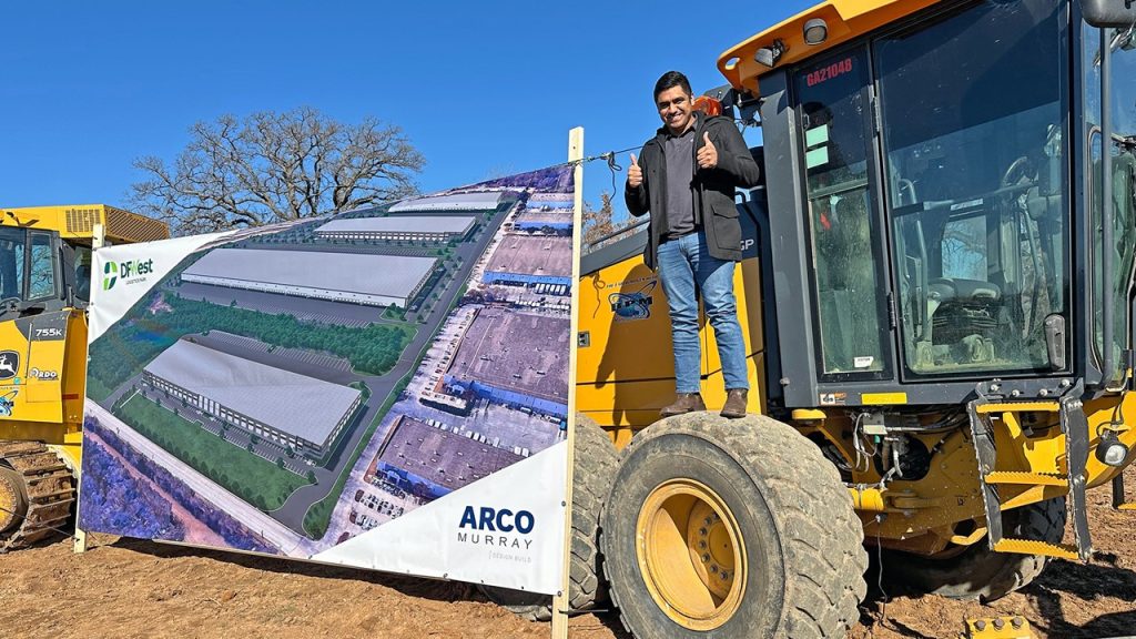 Halff employee standing on construction equipment at groundbreaking in Grapevine