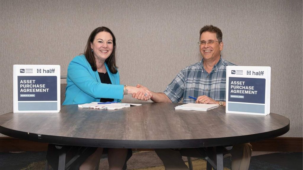 Halff President and CEO Jessica Baker Daily shaking hands with SAI during acquisition
